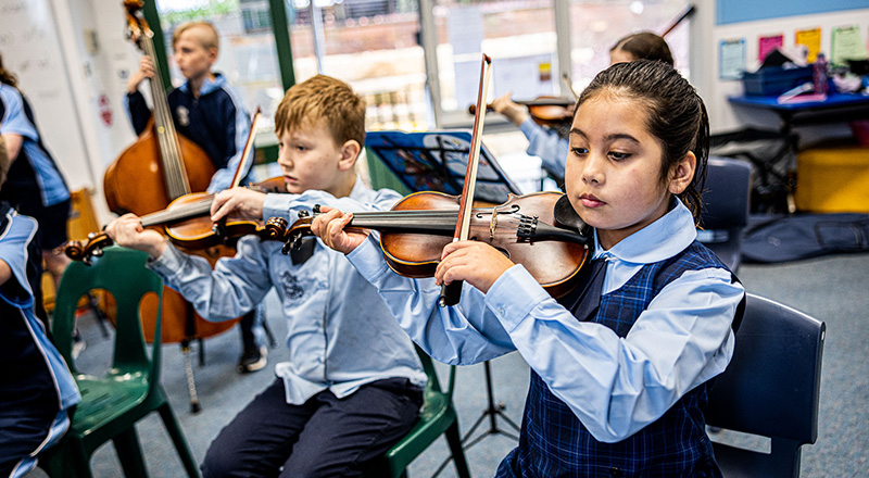 Our Lady of the Nativity Primary Lawson students learning violin in extracurricular music class