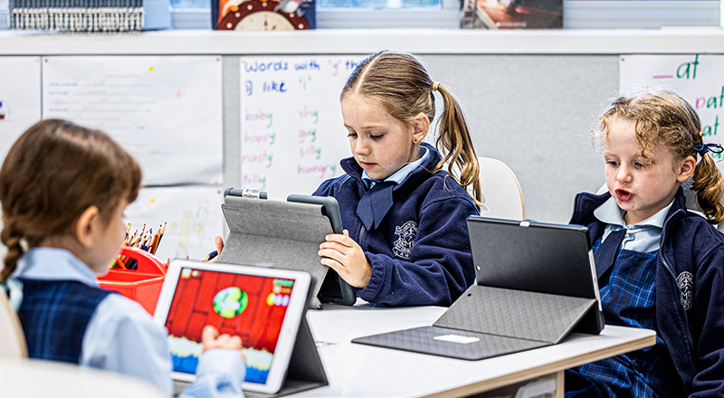 Three students using learning devices available at Our Lady of the Nativity Primary Lawson