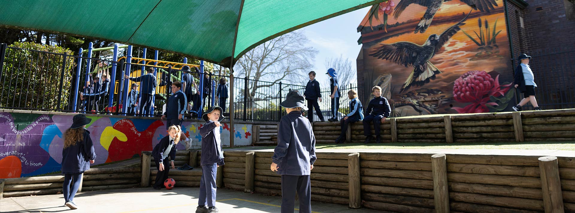 Before and after school care at Our Lady of the Nativity, Lawson. The students are playing soccer, and the playground equipment (Slides, monkey bars) is in the background.