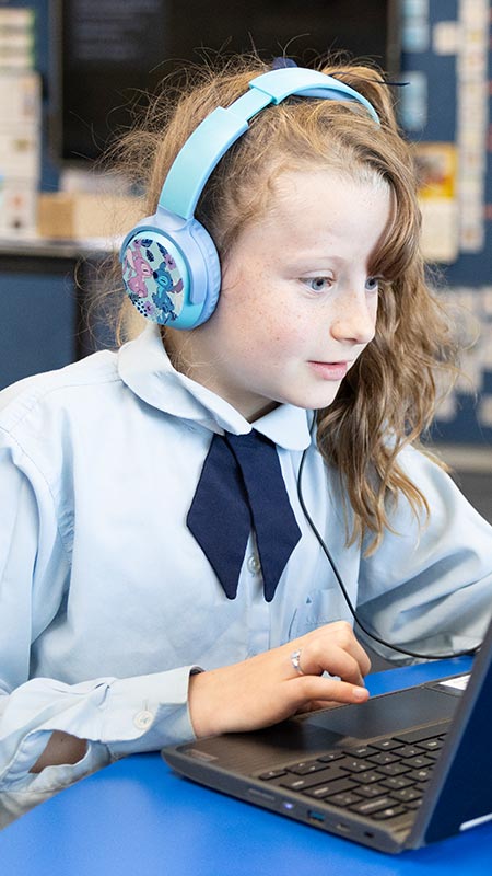 OLN Lawson student using a school laptop. She is also wearing headphones.