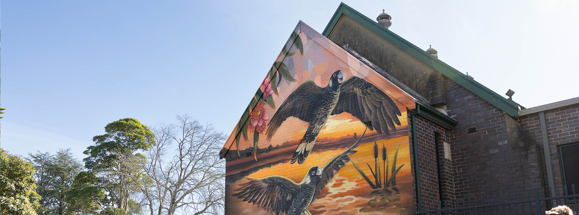 Outside view of the Church at Our Lady of the Nativity Primary Lawson. There is a mural of birds flying over Australian native bush