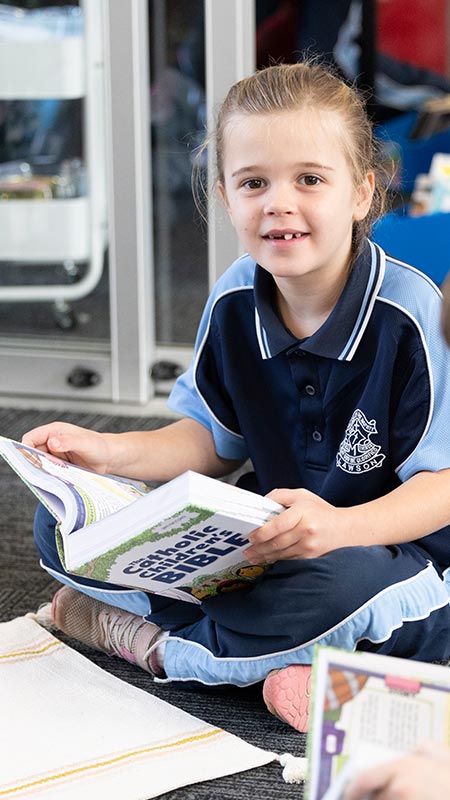 Our Lady of the Nativity Primary School Lawson student who is reading from a Children's Bible.