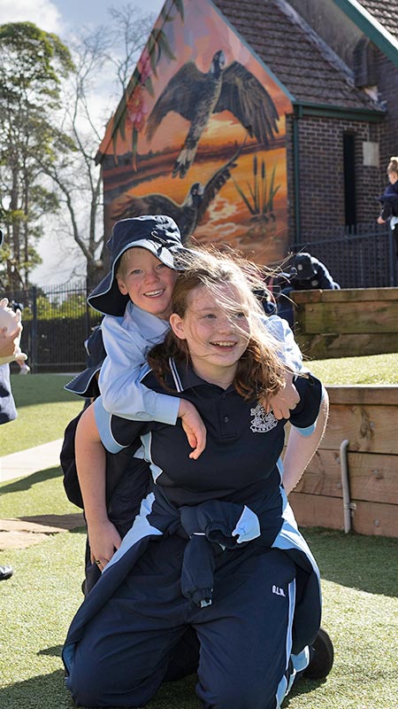 OLN Lawson student piggybacking another student around the playground