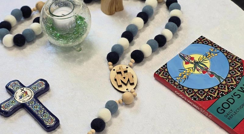 Religious symbolism (Cross, candle, Rosary beads) at Our Lady of the Nativity Primary Lawson