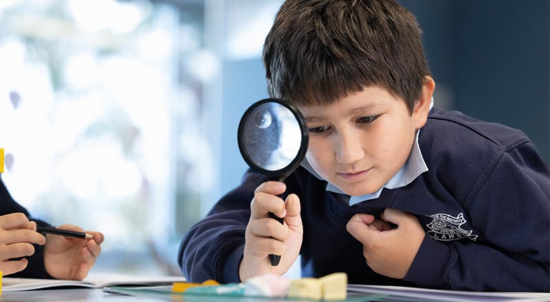 OLN Lawson student holding a magnifying glass