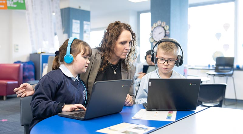 Our Lady of the Nativity Primary Lawson students in class. A teacher is assisting them.