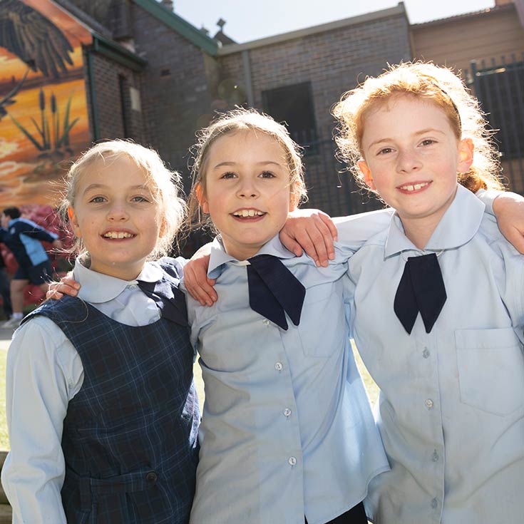 Three OLN Lawson students with their arms wrapped around each other.